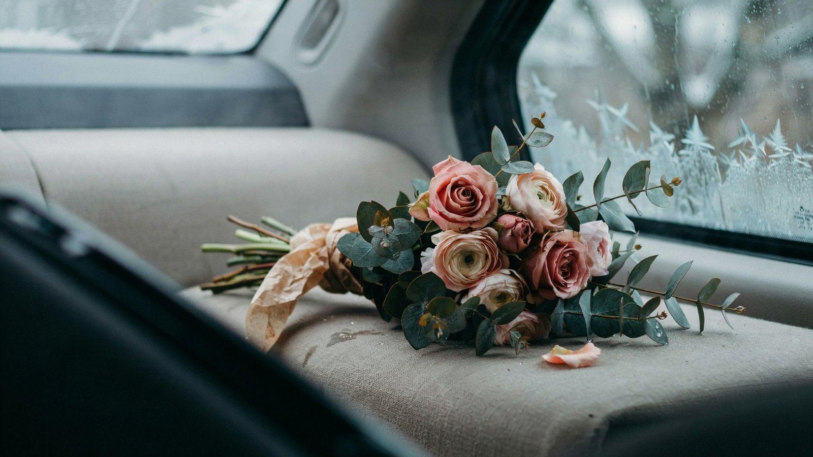 Wilted flowers inside cold frosty car interior showing winter damage and temperature effects concept illustration